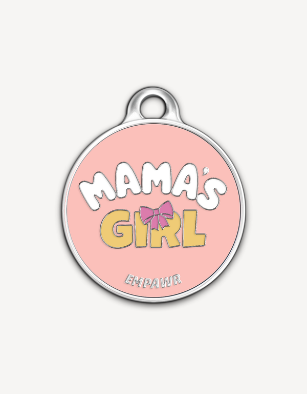 Empawr charm with the phrase "Mama's Girl" in yellow letters on a pink background, with a pink bow and silver trim. The brand name "EMPAWR" is at the bottom.